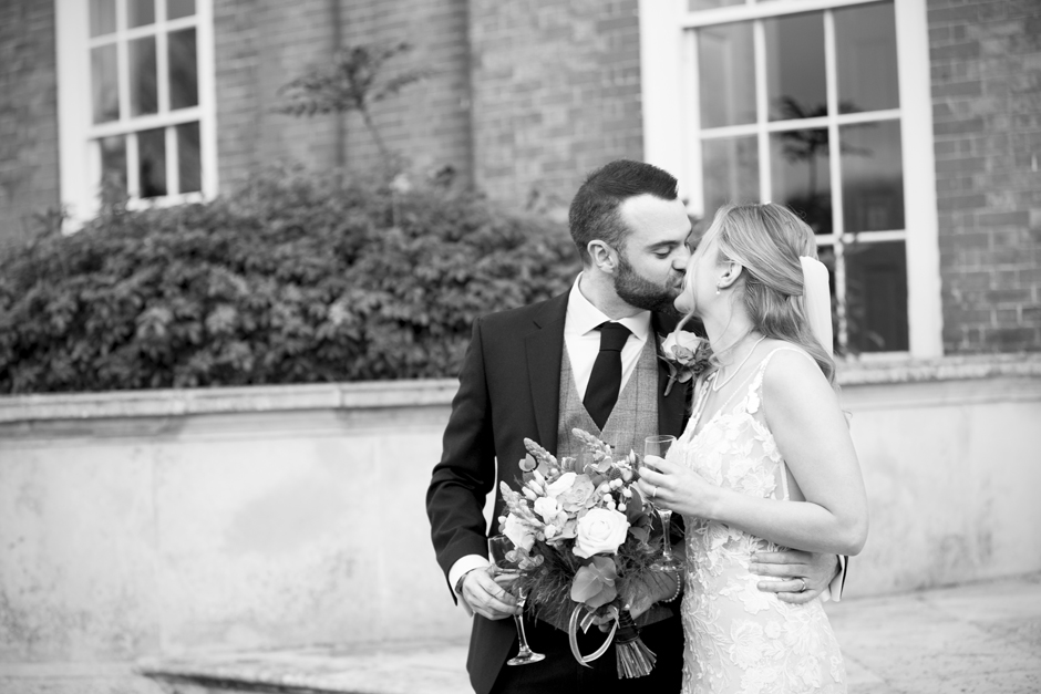 Bride and groom kissing outside Bradbourne House in East Malling, Kent.