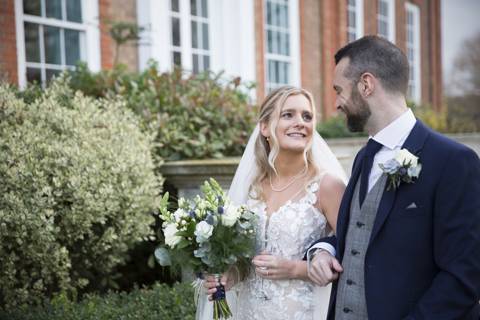 Bride looking lovingly at groom outside Bradbourne House in East Malling in Kent. Captured by Kent wedding photographer Victoria Green.