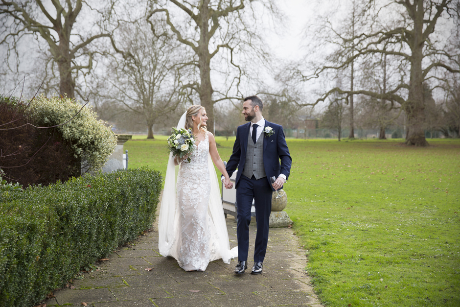 Bride and Groom holding hands walking in grounds at Bradbourne House in East Malling, Kent.