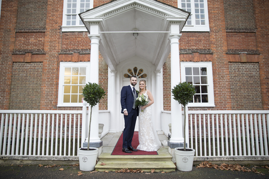 Bride and Groom under the white canopy entrance at Bradbourne House in East Malling, Kent.