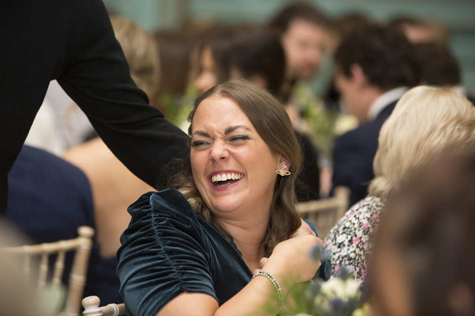 Female wedding guest laughing at Bradbourne House in East Malling, Kent.
