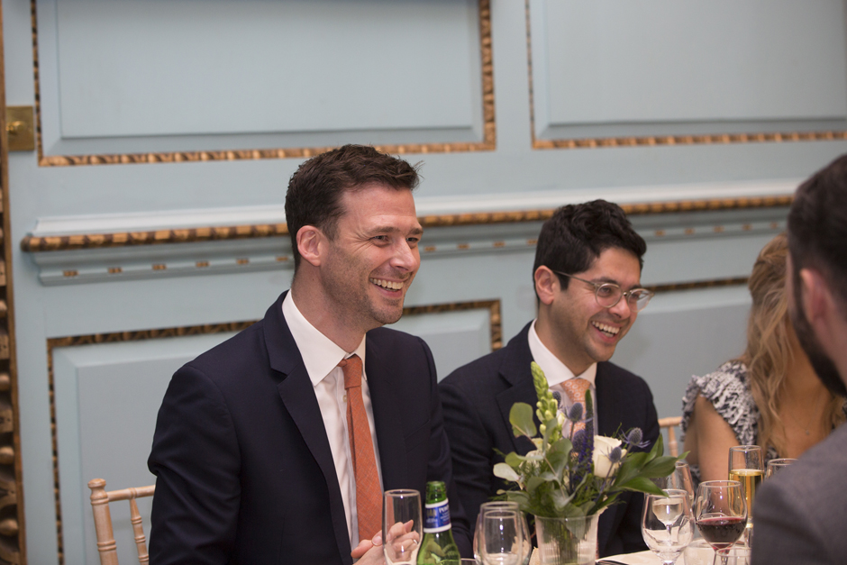 Male wedding guests seating laughing during wedding breakfast at Bradbourne House in East Malling, Kent.