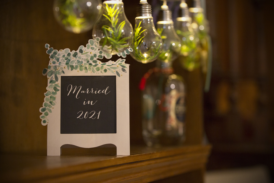 Sign reading 'Married in 2021' with light bulbs bunting filled with rosemary at Bradbourne House in East Malling, Kent.