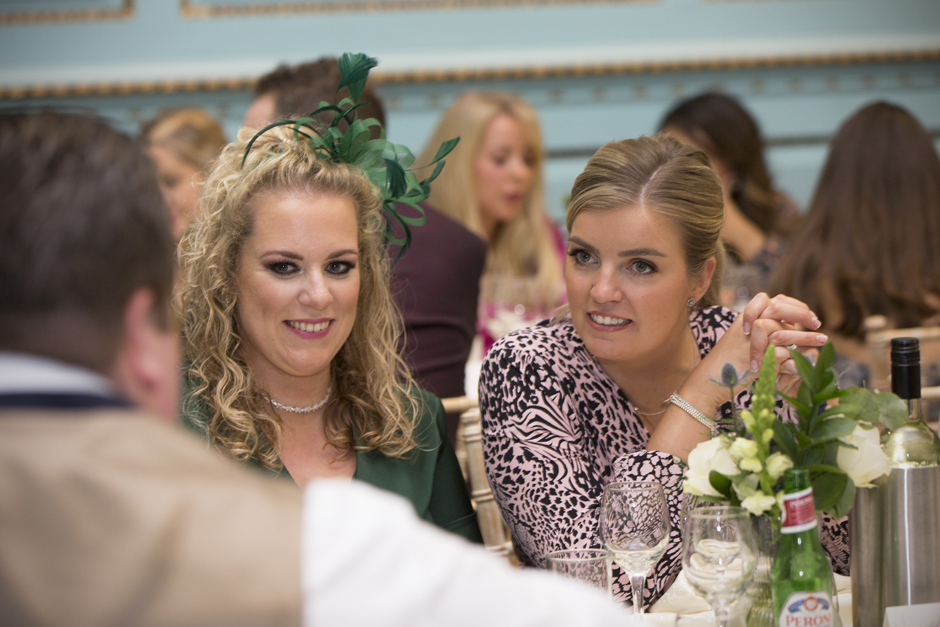 Female wedding guests listening to friend at wedding breakfast at Bradbourne House in East Malling, Kent.