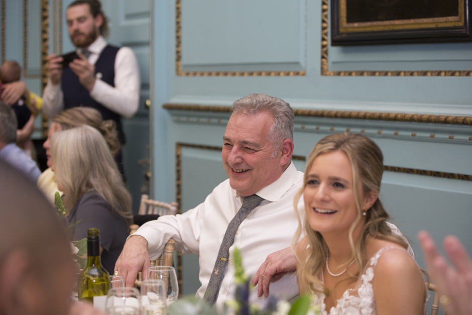 Bride and Bride's father laughing seated during wedding breakfast at Bradbourne House in East Malling, Kent.