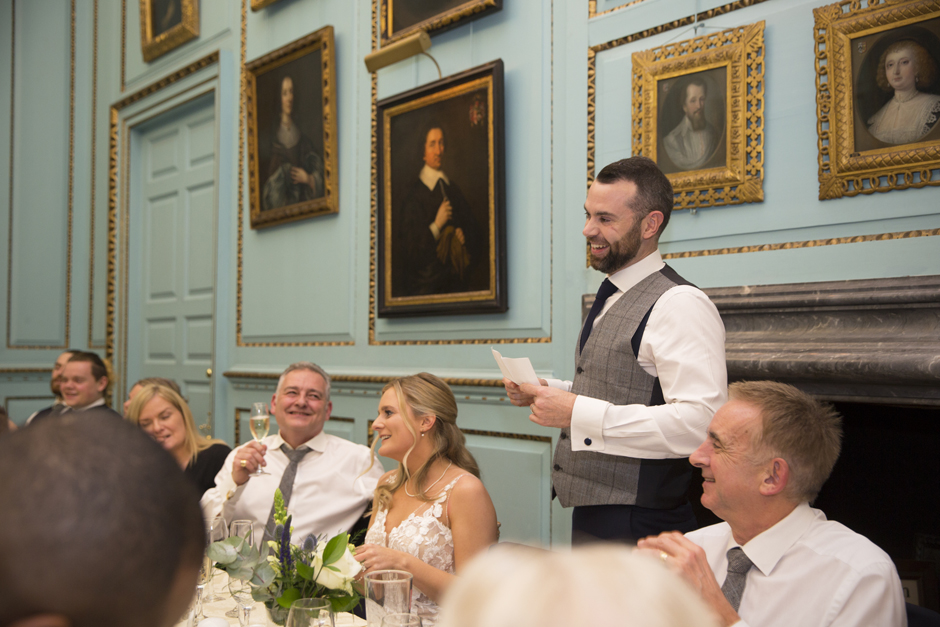 Groom standing reading speech at top table during wedding speeches at Bradbourne House in East Malling, Kent.