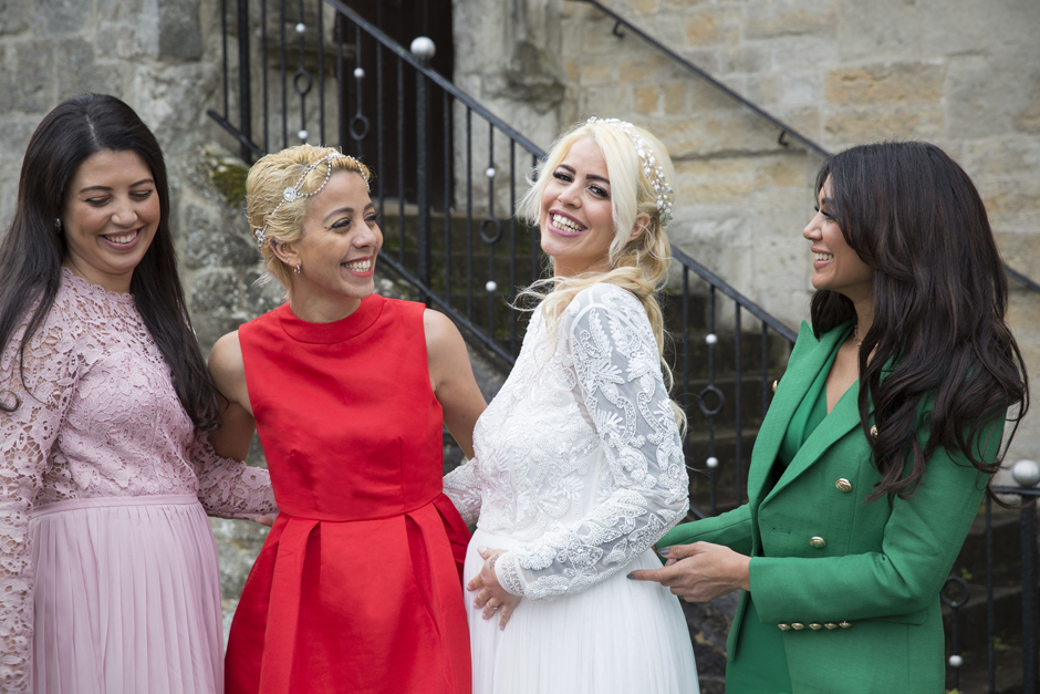 Bride laughing with her sisters outside Archbishop's Palace in Maidstone, Kent. Captured by Kent based wedding photographer, Victoria Green.