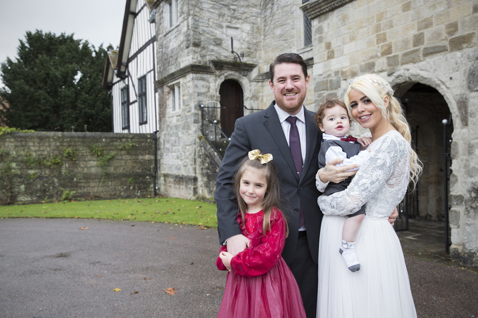 Bride and Groom with their children having a family portrait outside Archbishop's Palace Register Office in Maidstone, Kent. Captured by Victoria Green Photography.