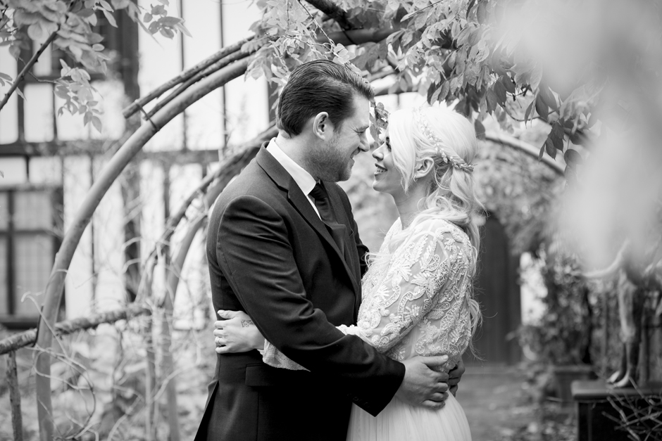 Bride and Groom in black and white under garden arch at Archbishop's Palace in Maidstone, Kent. Photographed by Kent wedding photographer Victoria Green.