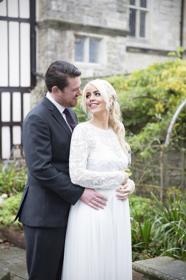 Bride looking lovingly up at groom in garden at Archbishop's Palace in Maidstone, Kent