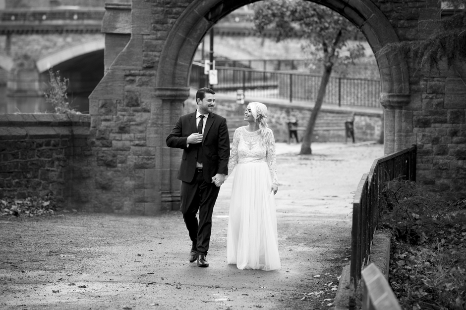 Bride and Groom walking under Maidstone Arch by the canal in kent. Captured by Victoria Green wedding photographer based in Kent.