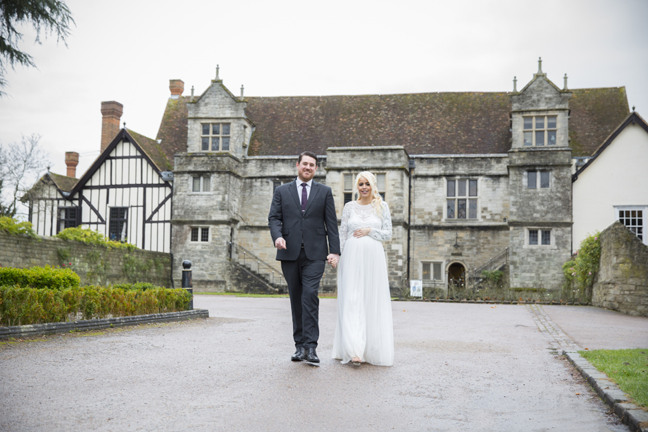 Groom and bride walking outside Archbishop's Palace in Maidstone, Kent.