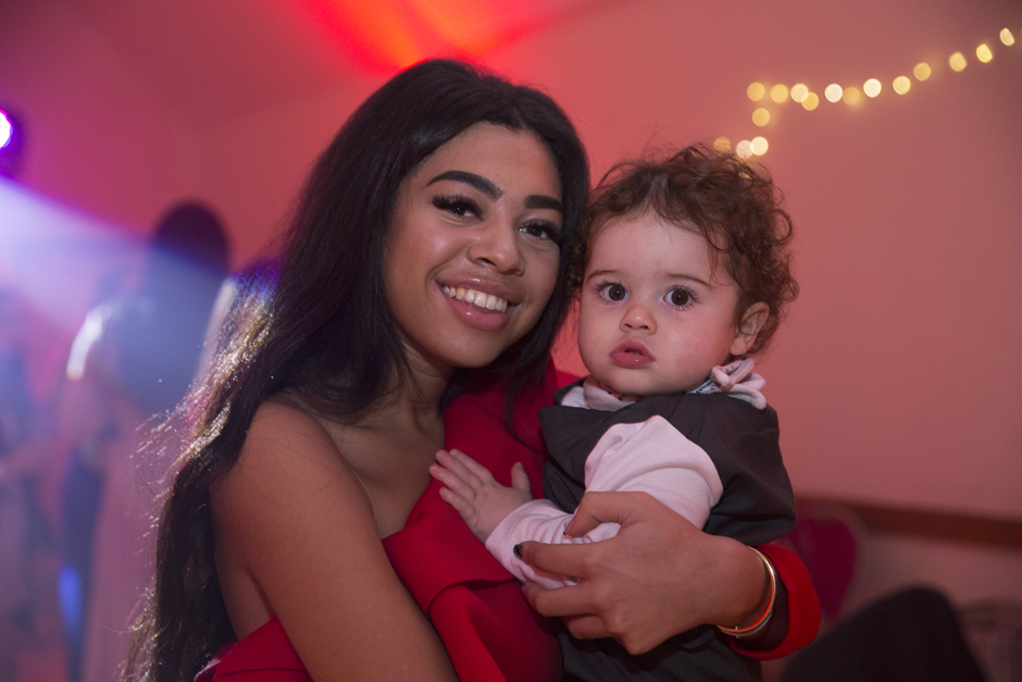 Wedding guest young lady holding baby boy at Sevenoaks wedding evening reception. Based in Kent.