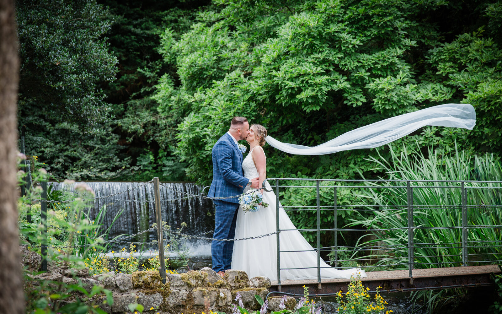 Bride and Groom kissing on the bridge at The Orangery in Maidstone, Kent. Captured by Kent wedding photographer Victoria Green.