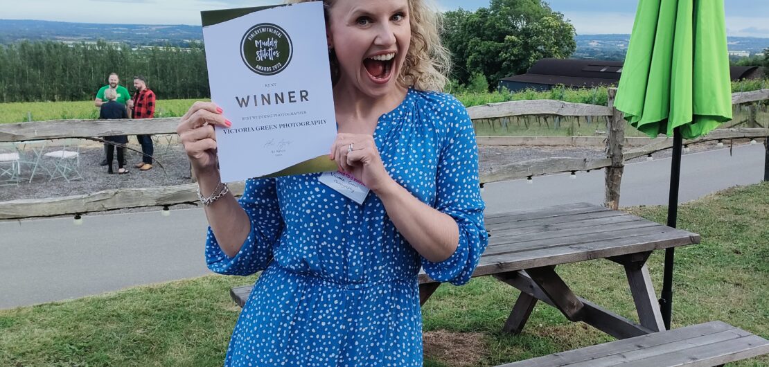 Victoria Green Wedding Photographer holding winners certificate for Muddy Stilettos Best Wedding Photographer 2023